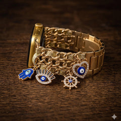 May include: Gold Apple Watch with a chain-style strap and hanging charms. The charms feature a blue hand, an eye, a heart, and a wheel, all with blue and white details. The watch is displayed on a dark wooden surface.