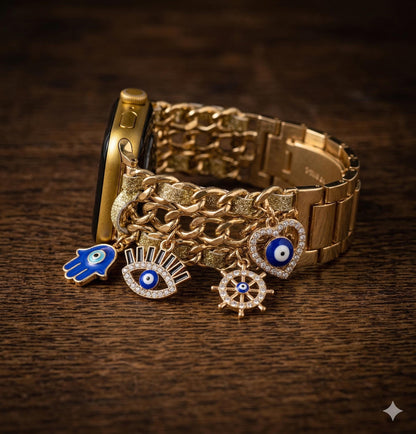 May include: Gold Apple Watch with a chain-style strap and hanging charms. The charms feature a blue hand, an eye, a heart, and a wheel, all with blue and white details. The watch is displayed on a dark wooden surface.